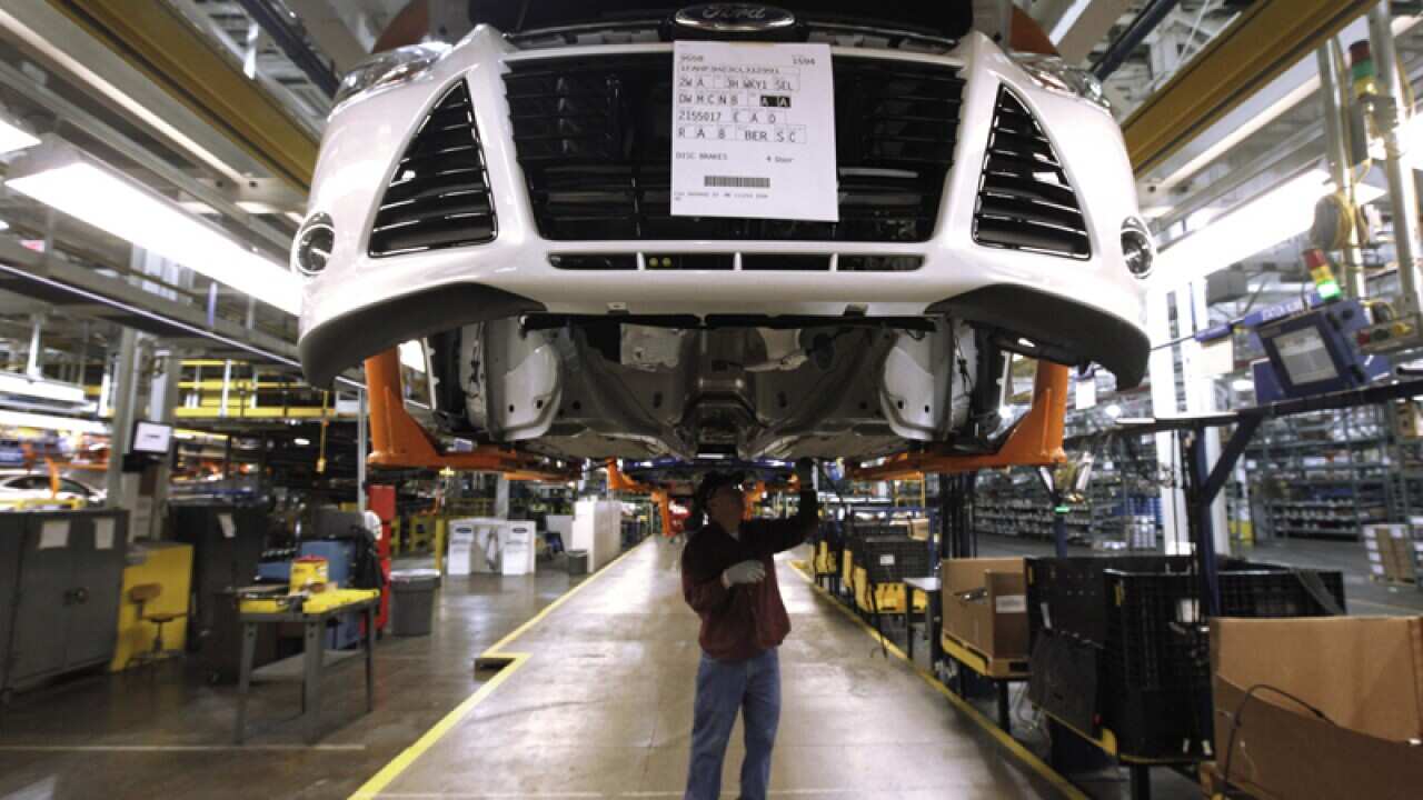 A line worker assembles a 2012 Ford Focus at the Ford Michigan