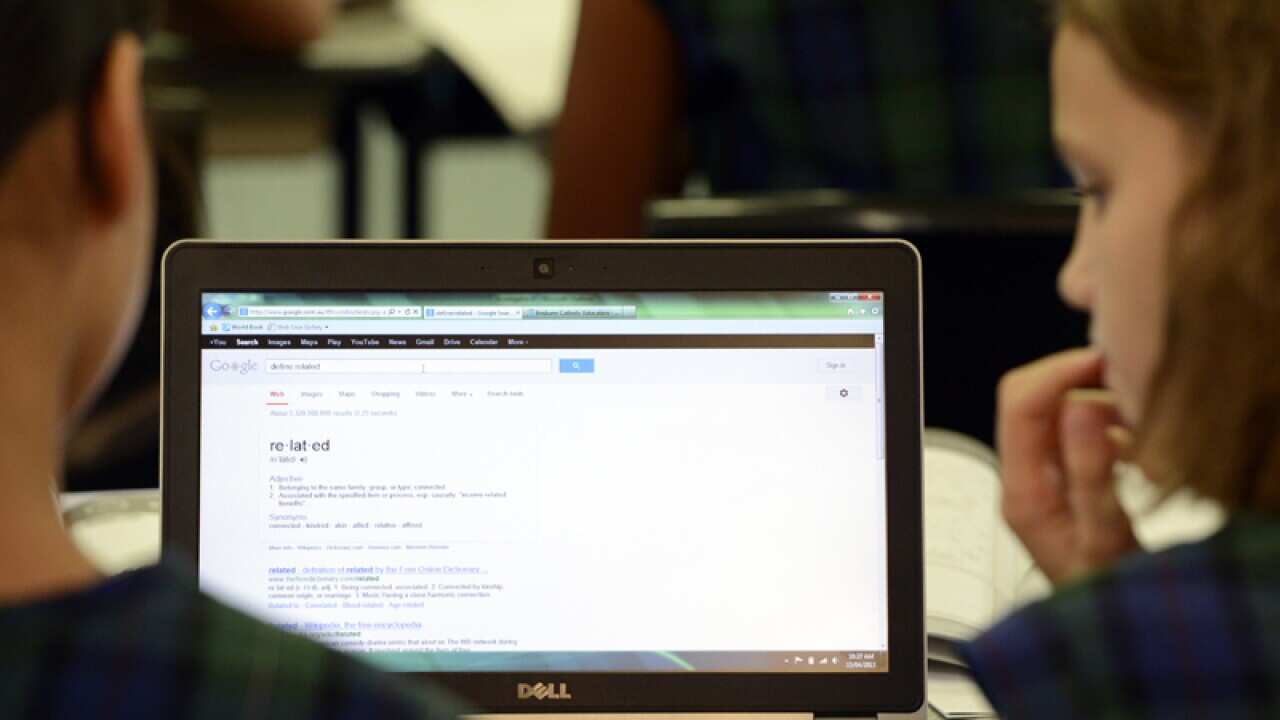 Primary school students use a laptop computer