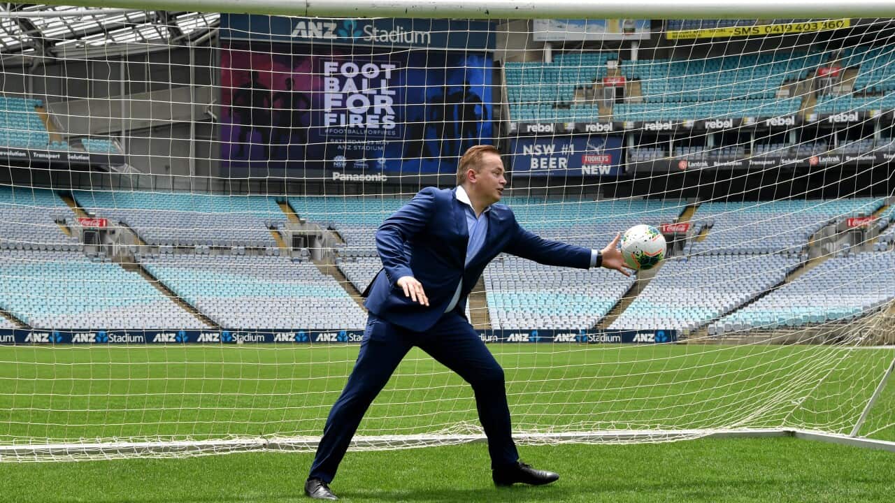 Former football star Mark Bosnich reaches for a ball in the net