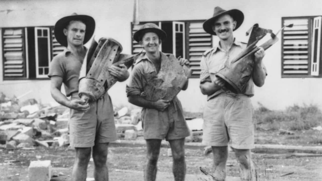 Holding parts of Japanese bombs dropped in Darwin