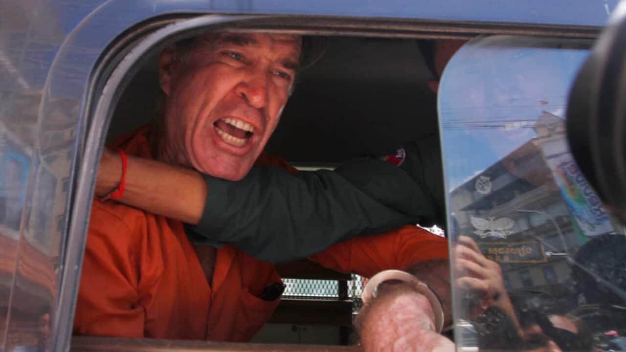 Australian filmmaker James Ricketson talks in a prisoner truck during a lunch break at Phnom Penh Municipal Court, in Phnom Penh, Cambodia
