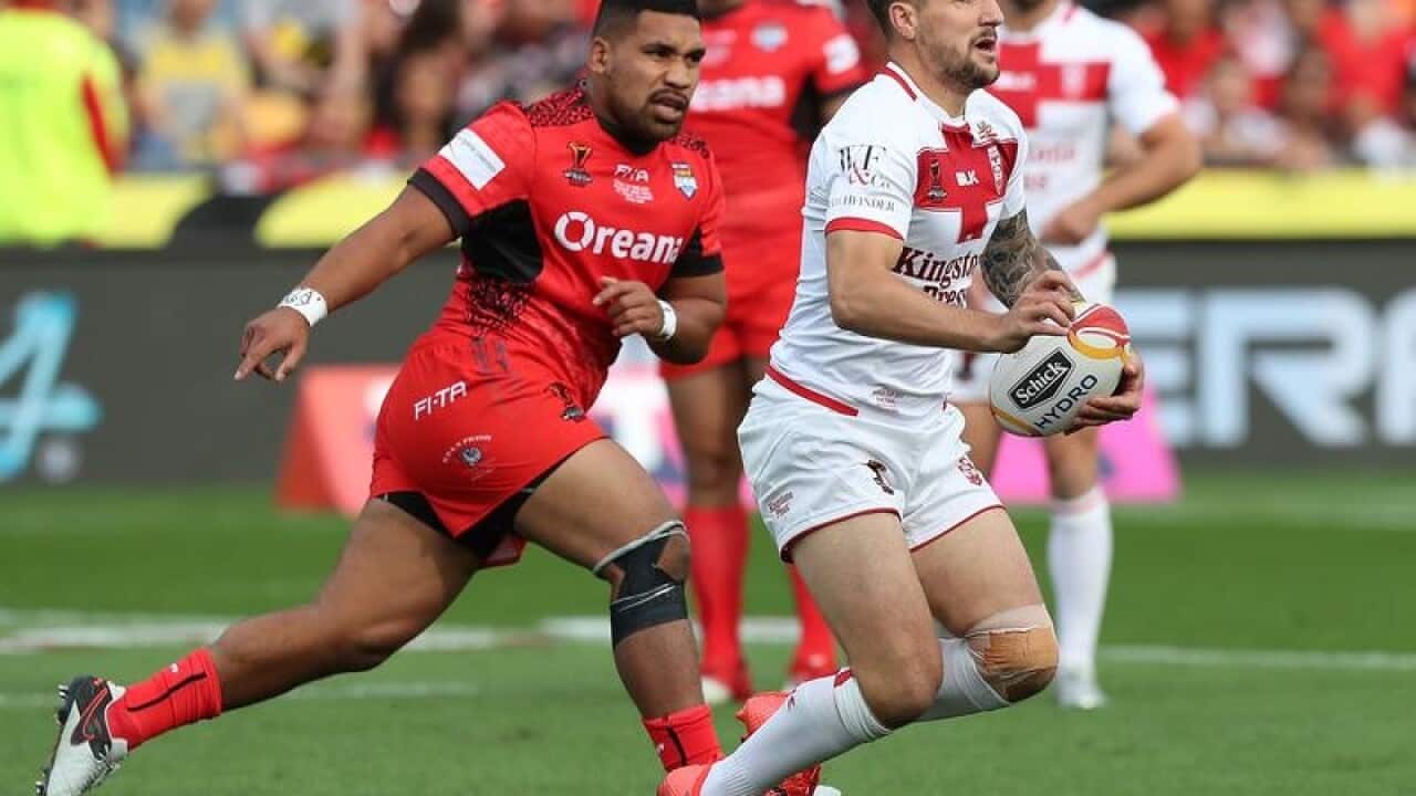 Luke Gale of England is chased by Siliva Havili of Tonga.