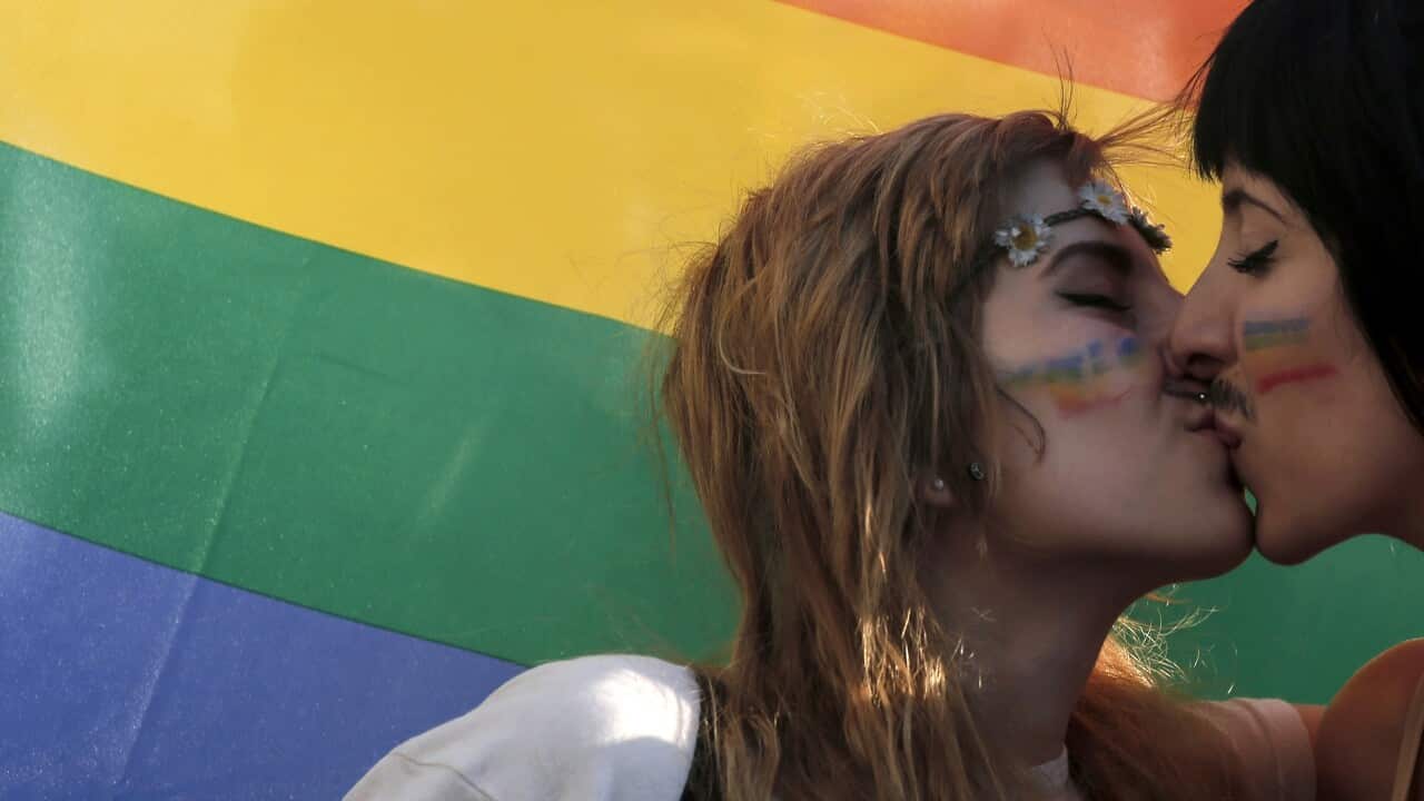 Couple kiss under pride flag in Athens