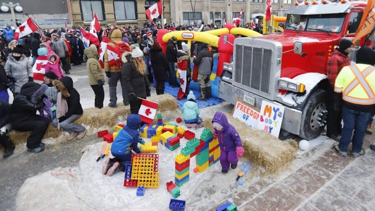 캐나다 오타와 시내의 통행을 막은 백신 의무화 반대 시위 트럭 앞에서 어린이들이 놀고 있다.