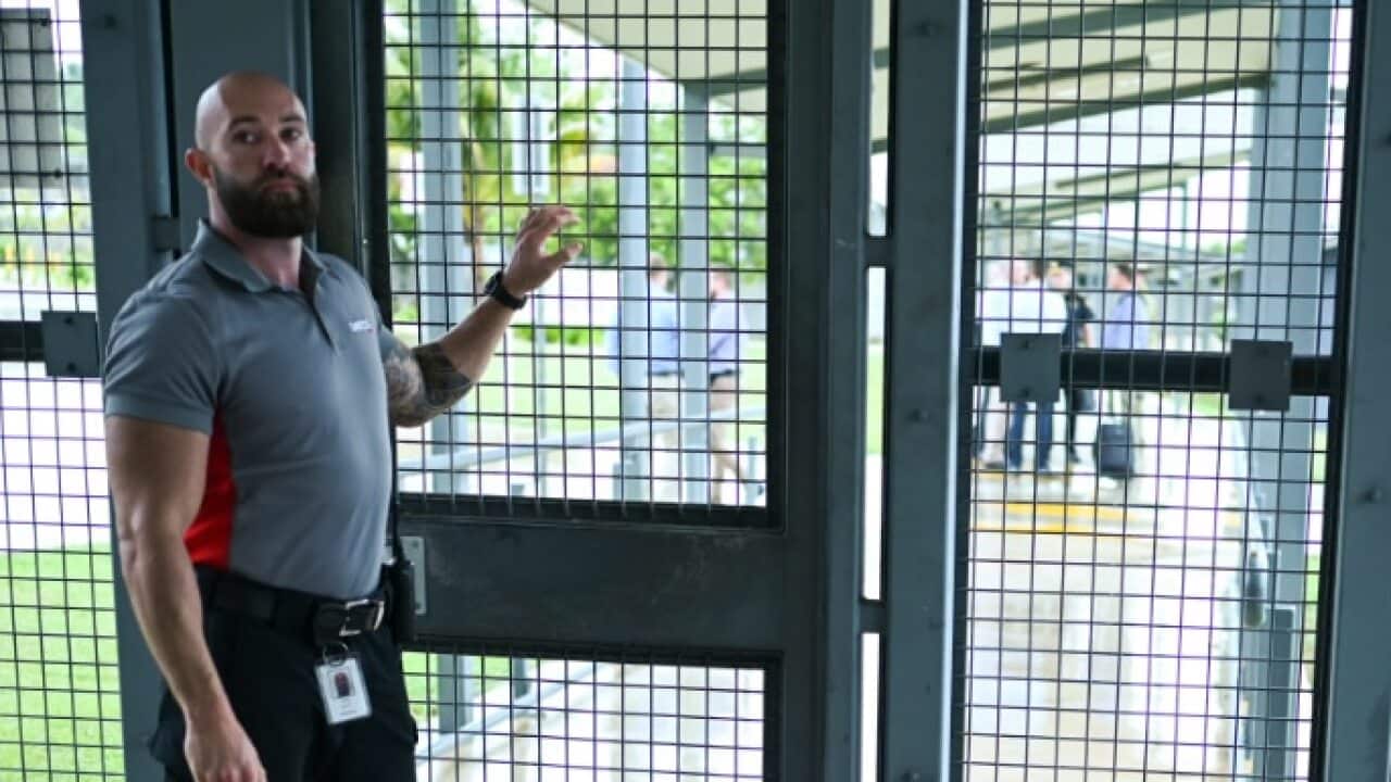 A guard stands at the entry door during a tour of the North West Point Detention Centre on Christmas Island.