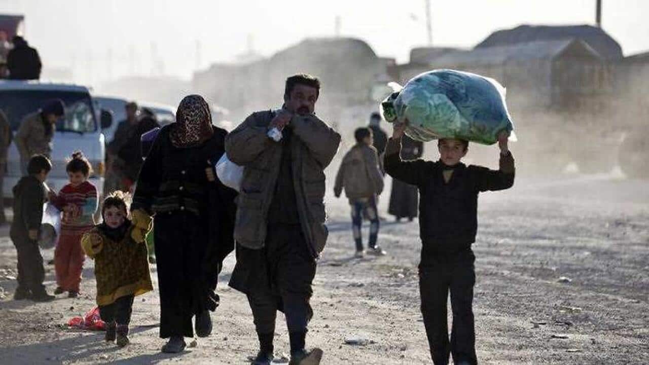 Syrians walk towards the Turkish border at the Bab al-Salam border gate, Syria (AAP)