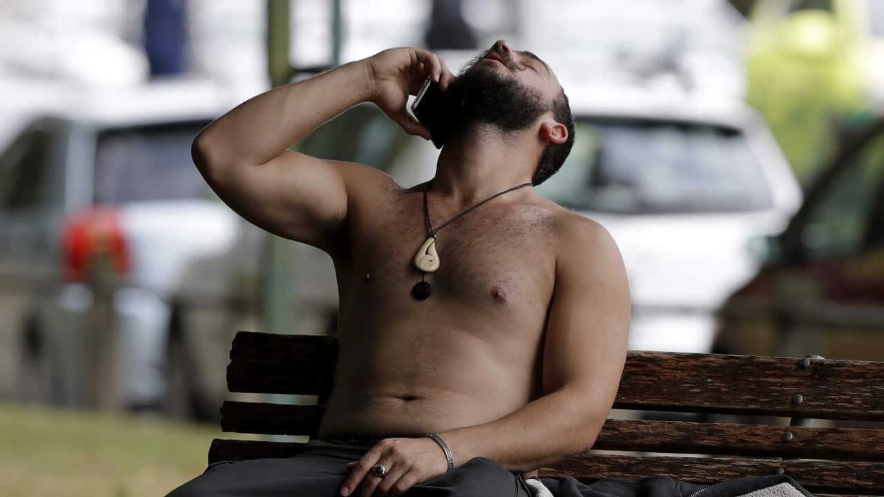 A man reacts as he speaks on a mobile phone outside a mosque in central Christchurch, New Zealand.