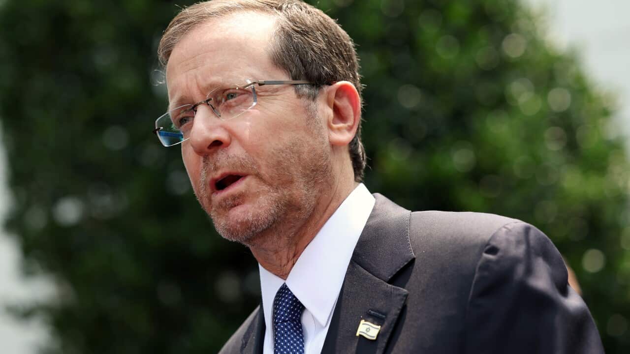 A man in a black suit, white shirt, blue tie and blue and white Israeli flag pin.