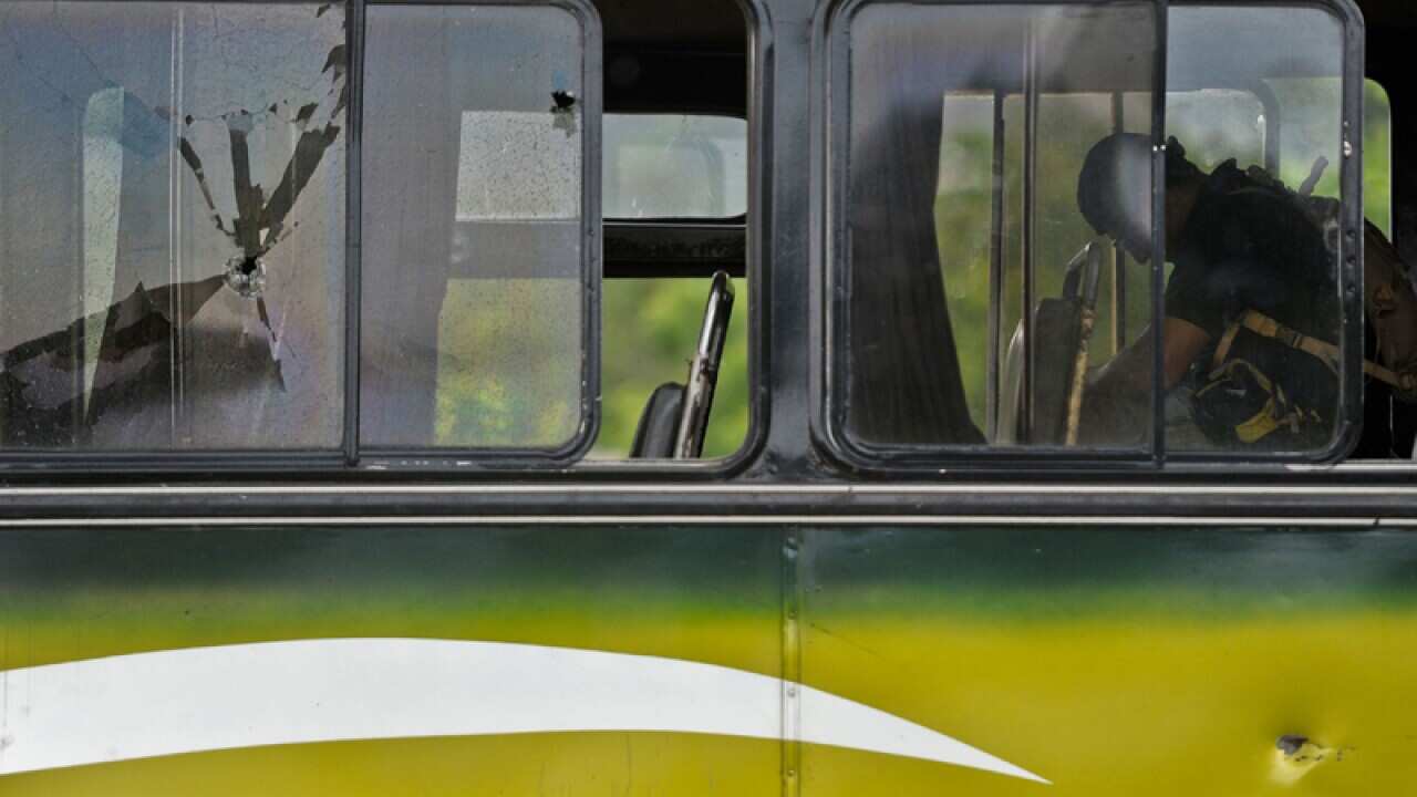 A police investigator inspects the bus in El Salvador