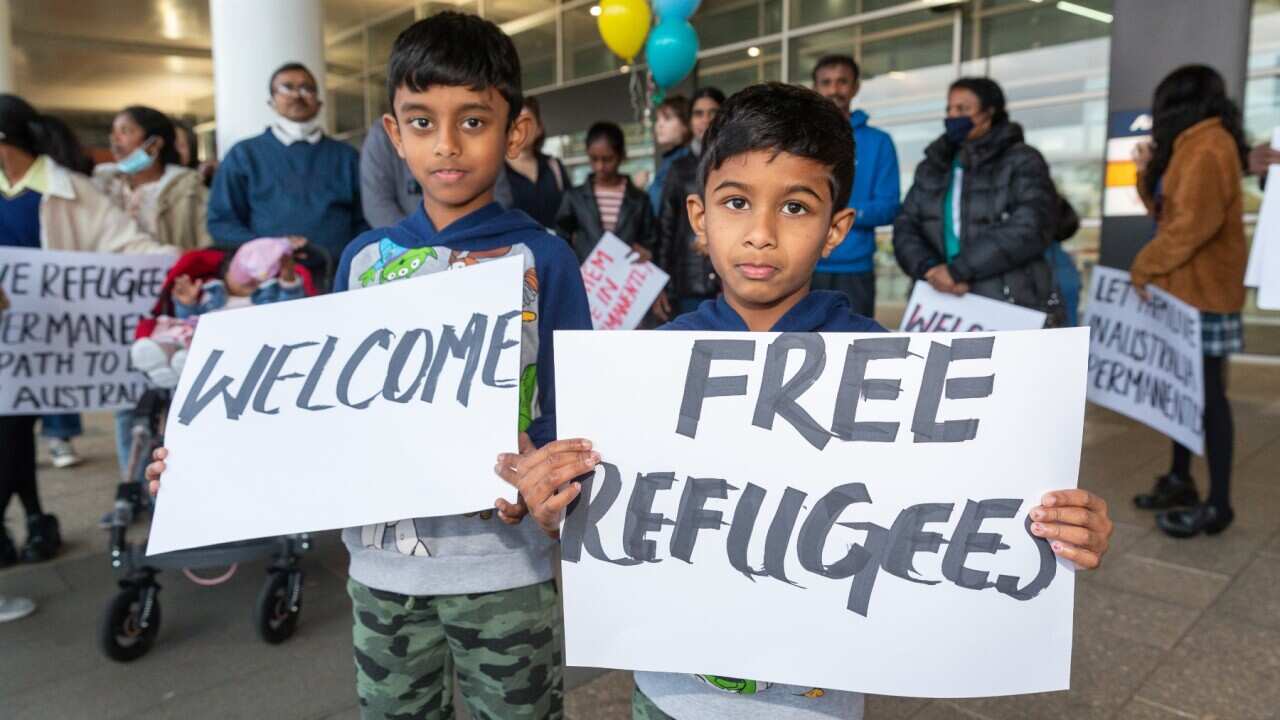 Supporters of the Tamil asylum-seeker Murugappan family are seen holding signs at Perth airport, Tuesday, June 15, 2021