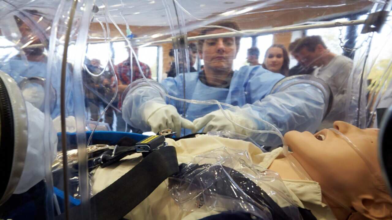 A nurse looks at a Ebola Transport isolator in Germany.