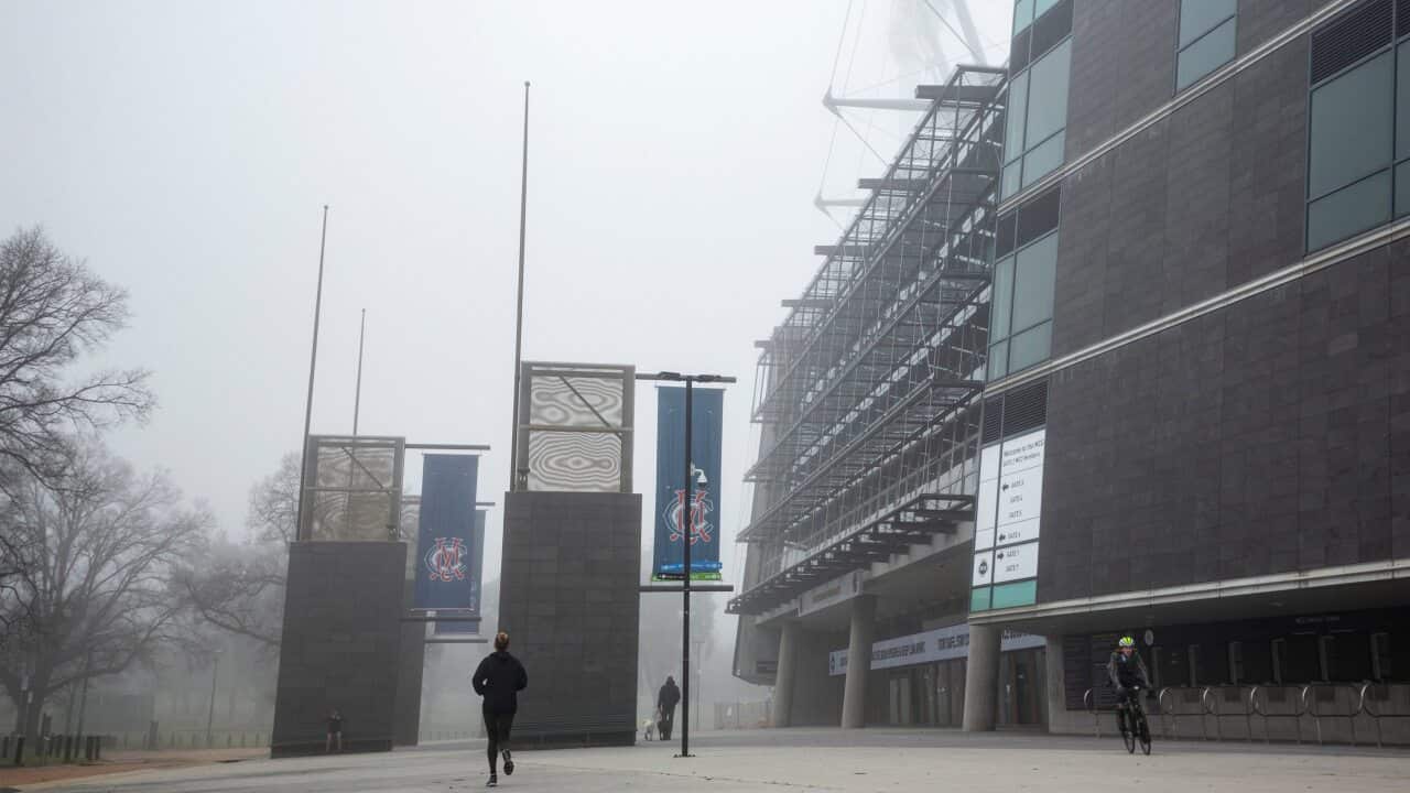 People exercise near the MCG in Melbourne, Friday, July 17, 2020. (AAP Image/Daniel Pockett) NO ARCHIVING