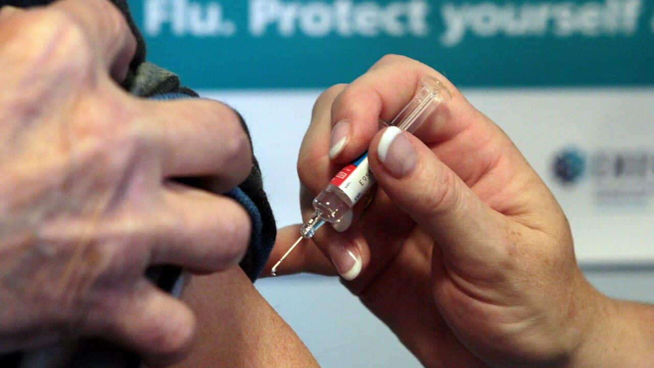 A person administers a flu vaccine.
