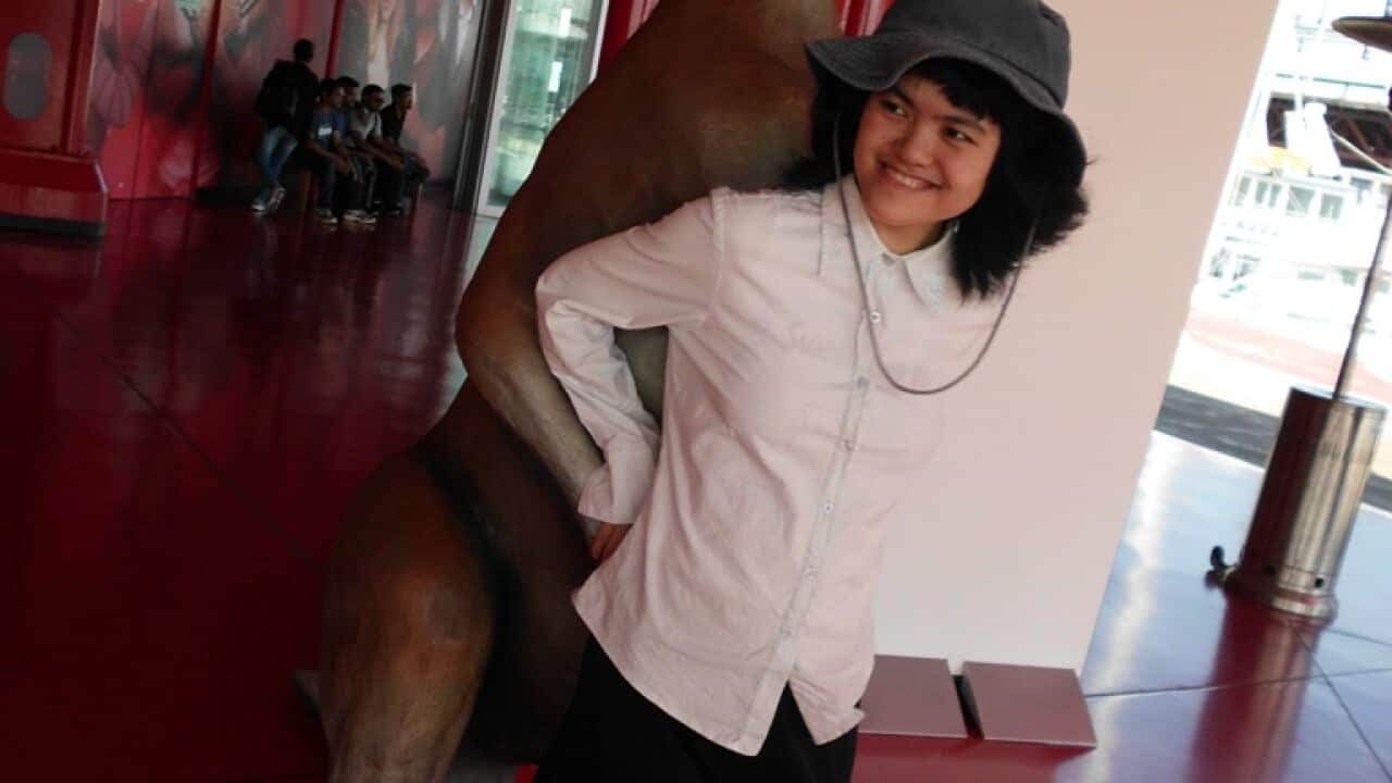 Shoko stands in front of a kangaroo statue at a wild park.