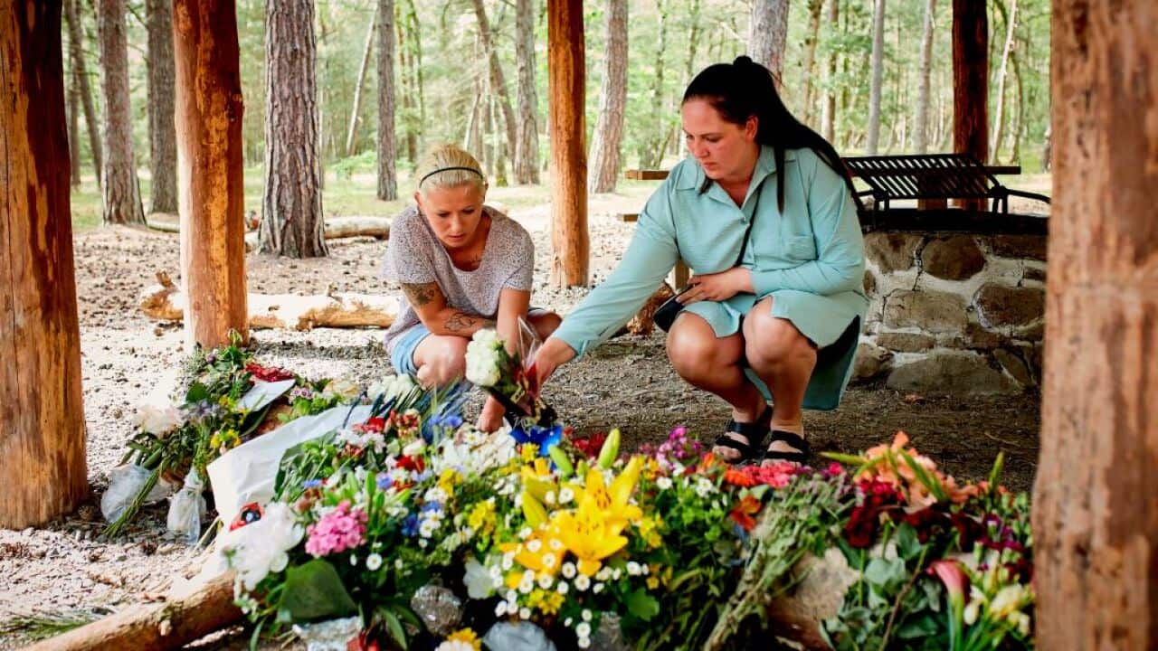 Women lay flowers at a shelter where 28-year-old Phillip Mbuji Johansen was found dead. 