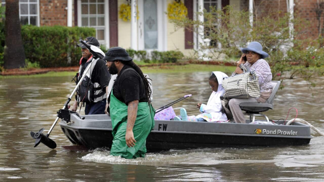 Volunteers pull a boat with evacuees from floodwaters