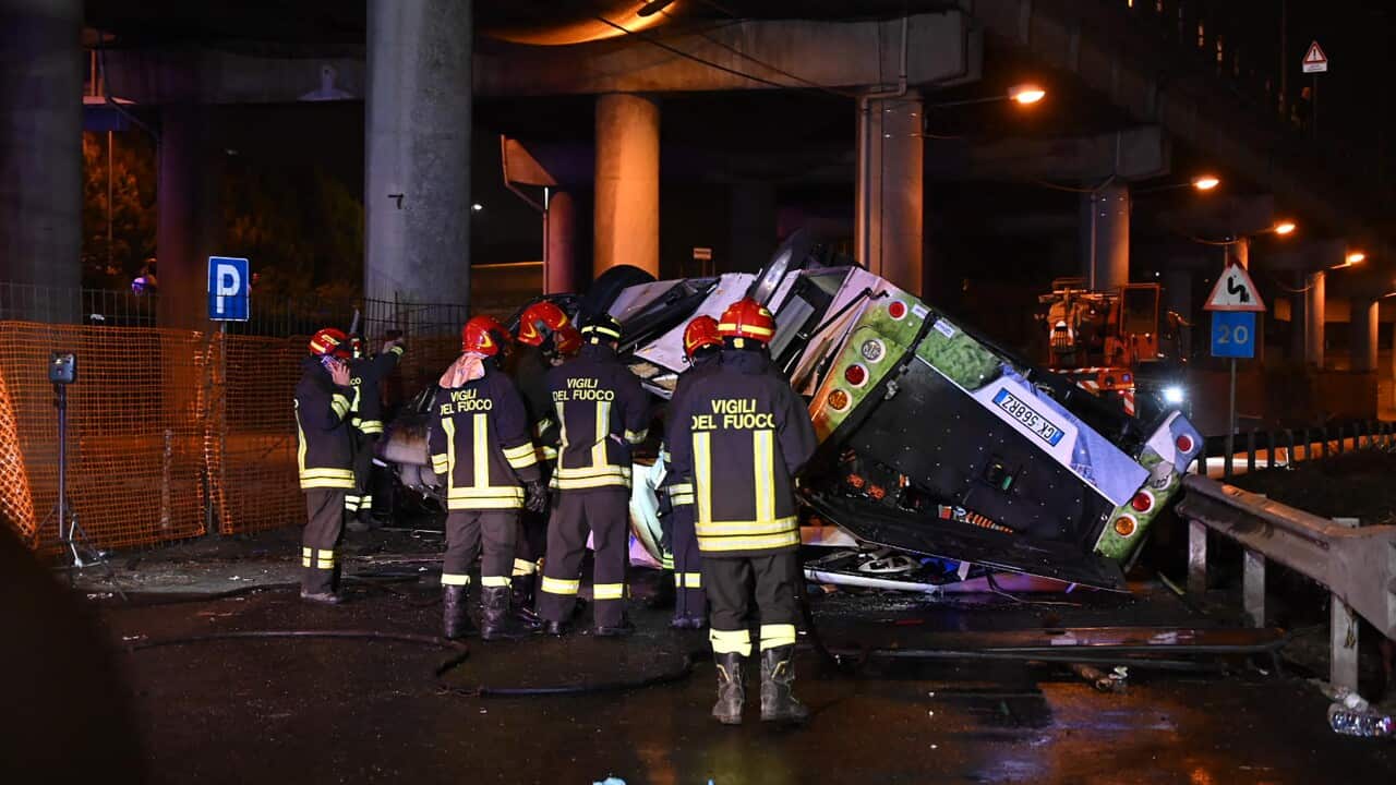Firefighters stand in front of the wreckage of a bus crash in Mestre, near Venice.