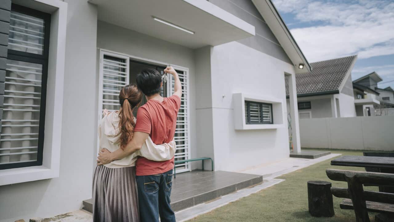 asian chinese young couple just received house key for their new house happy