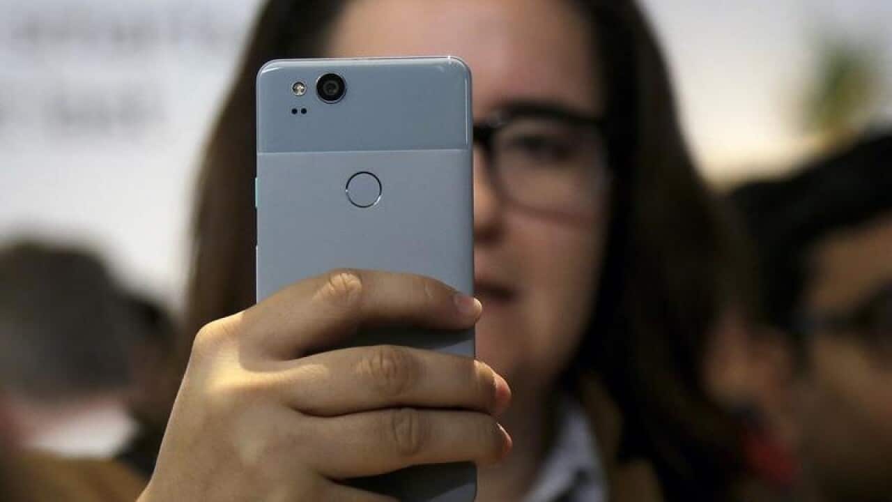 A woman looks at a Google Pixel 2 phone