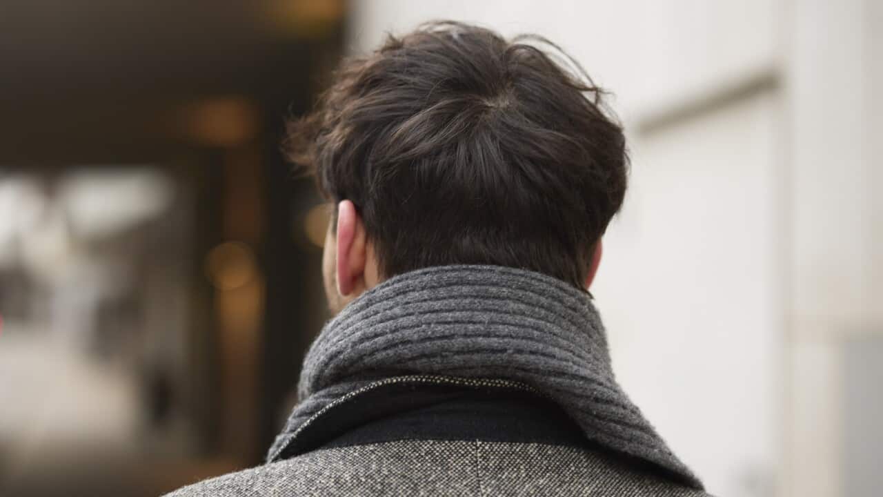 Rear of a man walking down a street