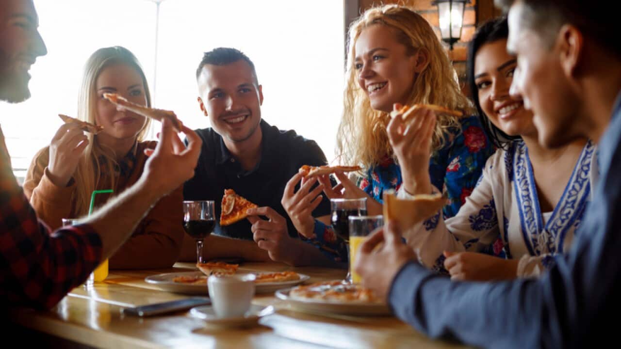 Group of students eating pizza