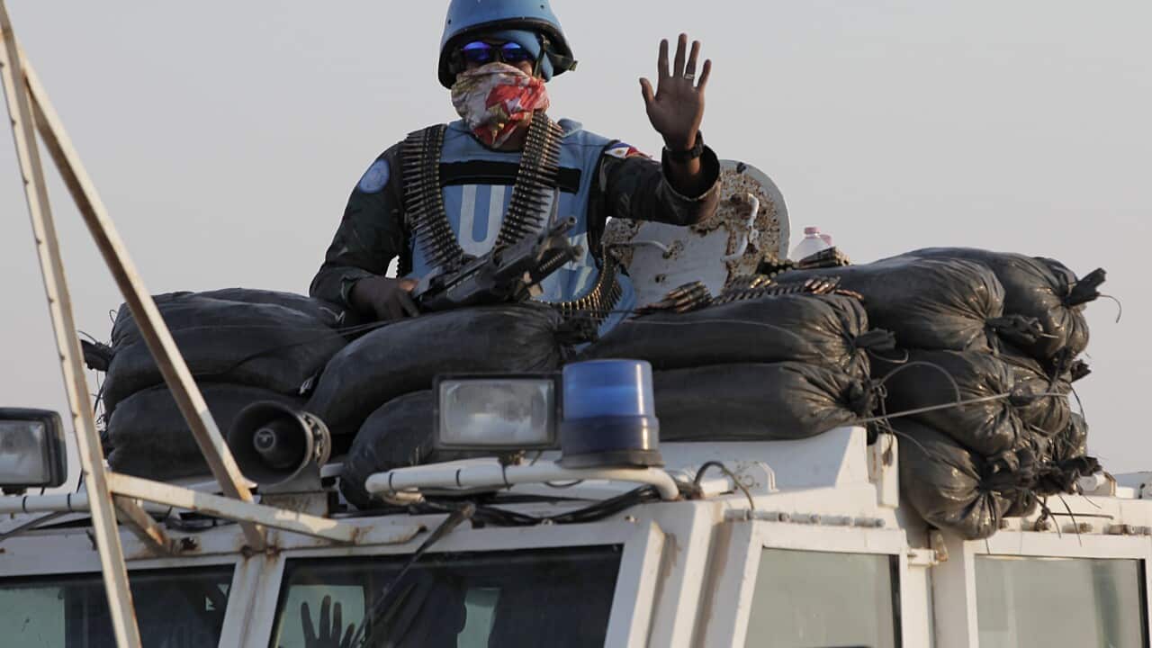 Members of the United Nations Disengagement Observer Force (UNDOF) wave as they drive their armoured vehicle in the Israeli-annexed Golan Heights on August 30, 2014.