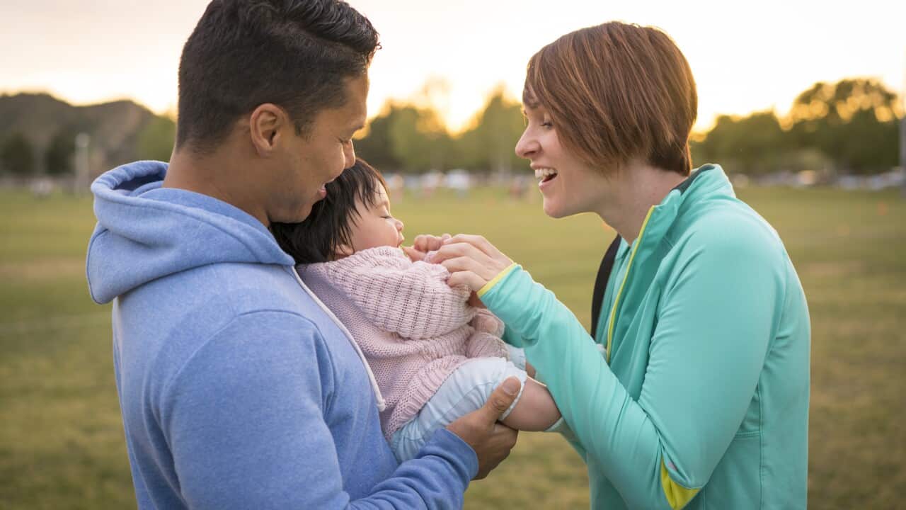Couple playing with baby in park