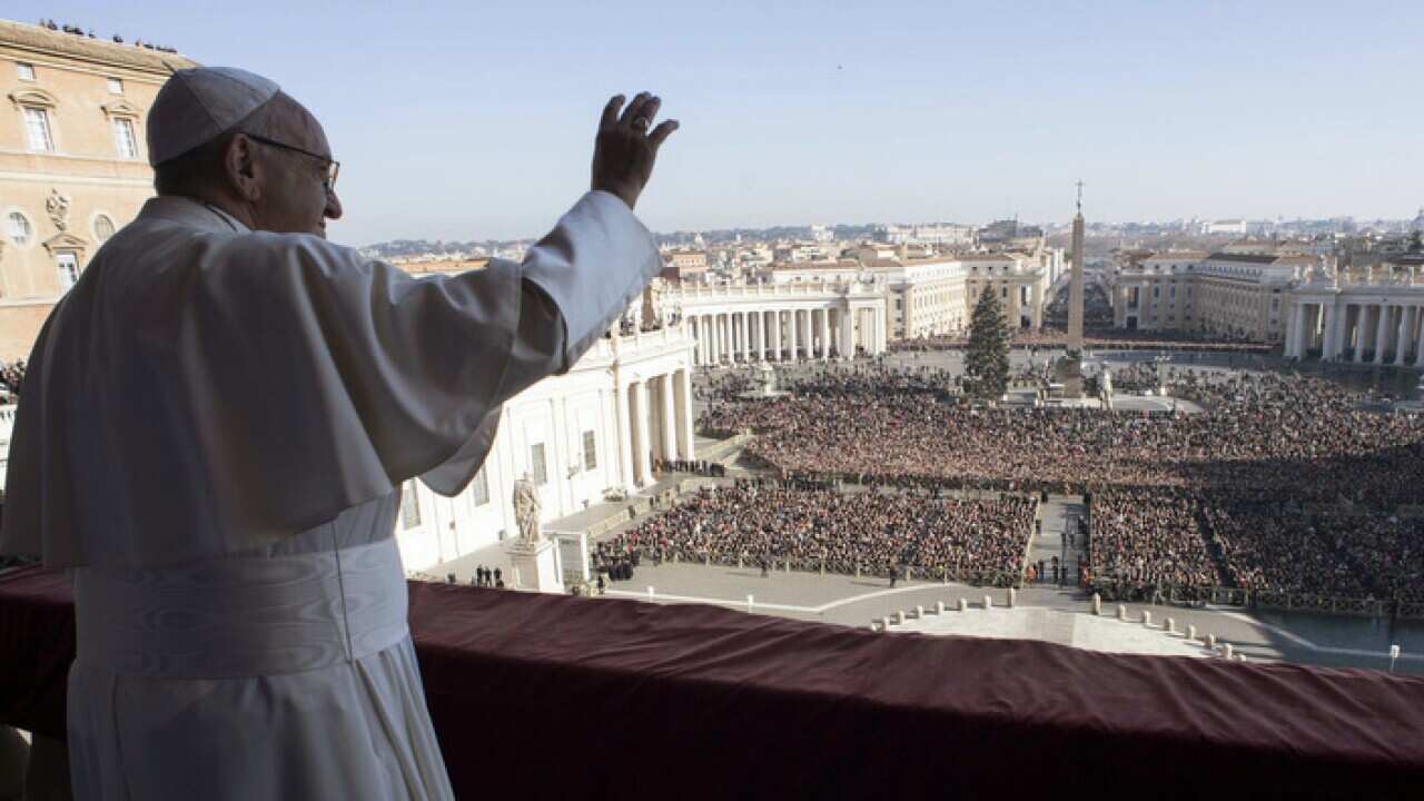 Pope Francis waves to faithful during the Urbi et Orbi (Latin for ' to the city and to the world') Christmas' day blessing from the main balcony of St. Peter's Basilica at the Vatican, Monday, Dec. 25, 2017. (L'Osservatore Romano/Pool Photo Via AP)