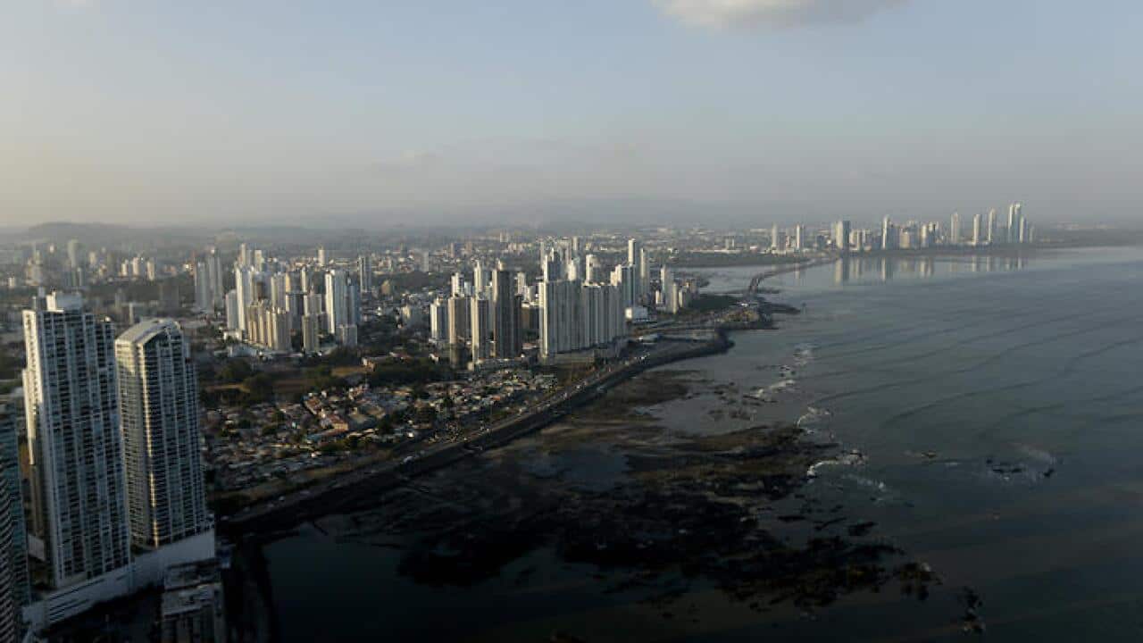 The setting sun lights up the Panama City skyline, Monday, April 4, 2016. (AAP)