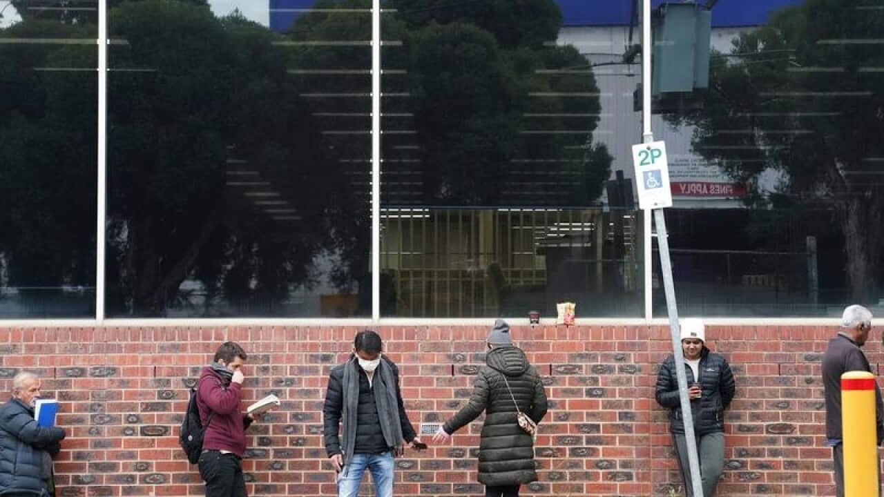People are seen queuing outside a yet to open Centrelink office.