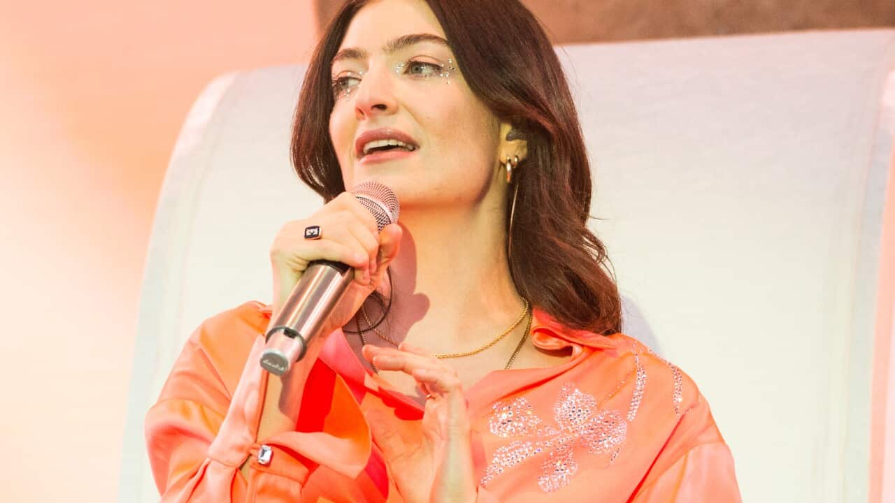 New Zealand singer-songwriter Lorde holding a microphone.