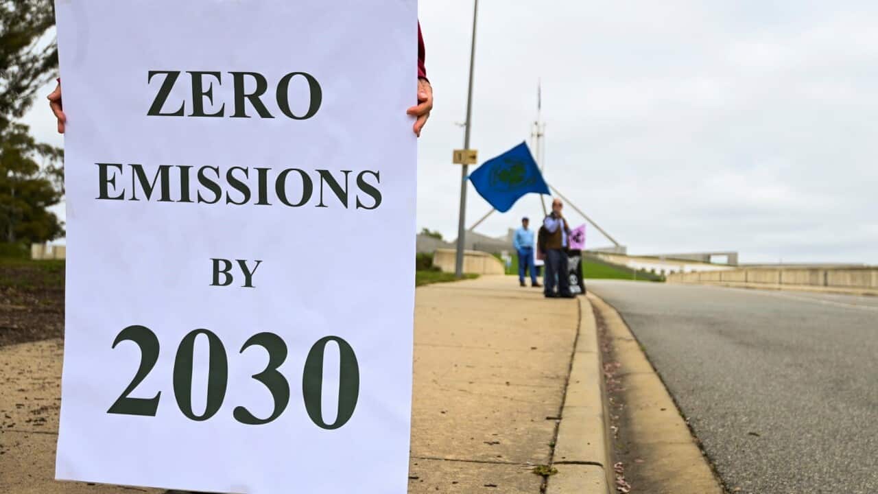 People hold banners as they participate in a climate protest outside Parliament in Canberra, Monday, November 9, 2020. (AAP Image/Lukas Coch) NO ARCHIVING