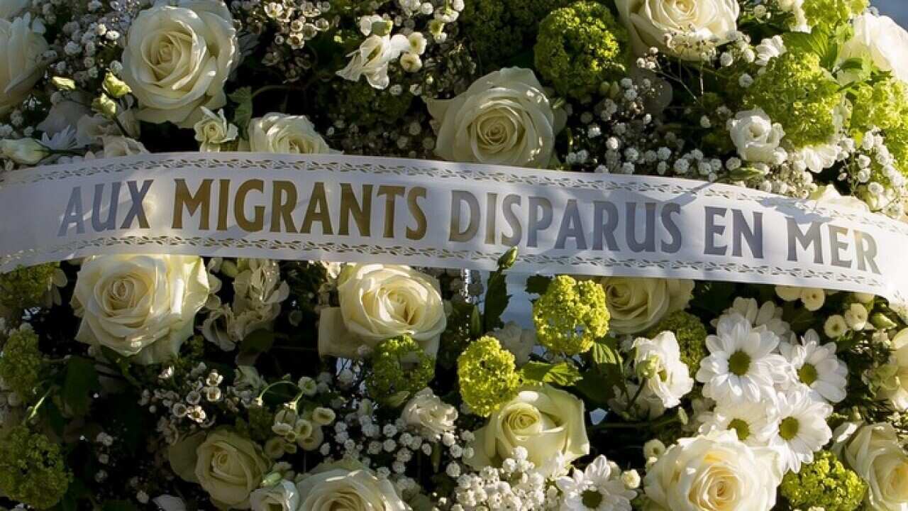 A wreath bearing the message 'For the migrants lost at sea' at an Amnesty rally