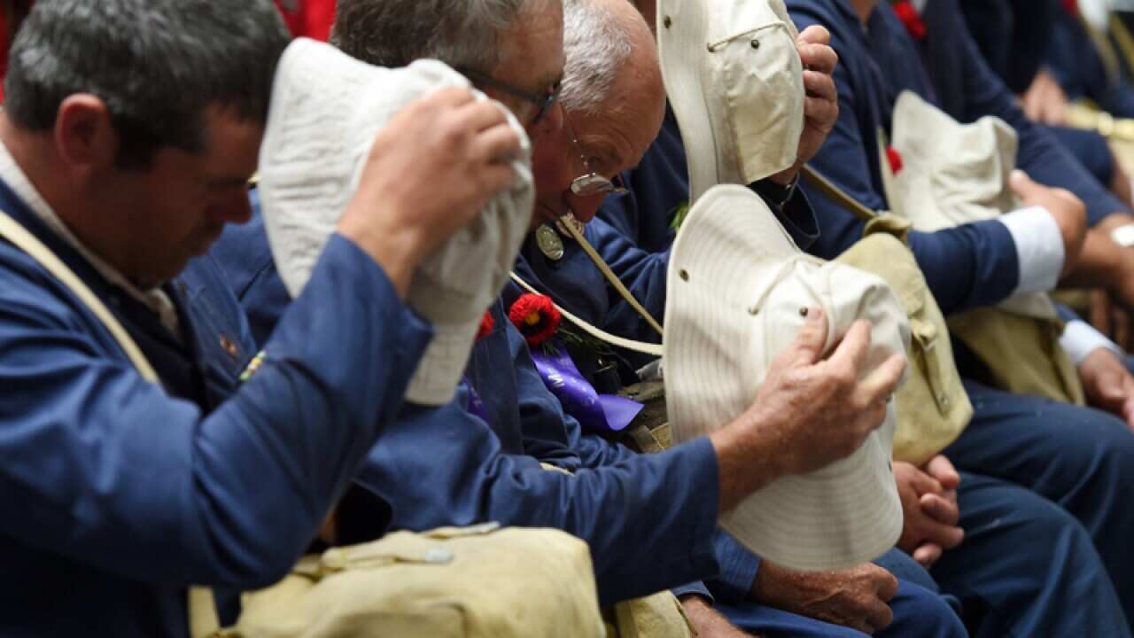 Attendees remove their hats for a moment of silence