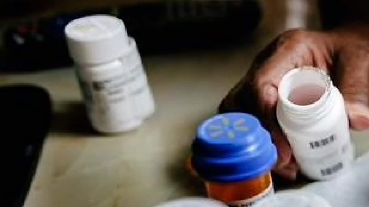 An older person sorting her medicines for the week