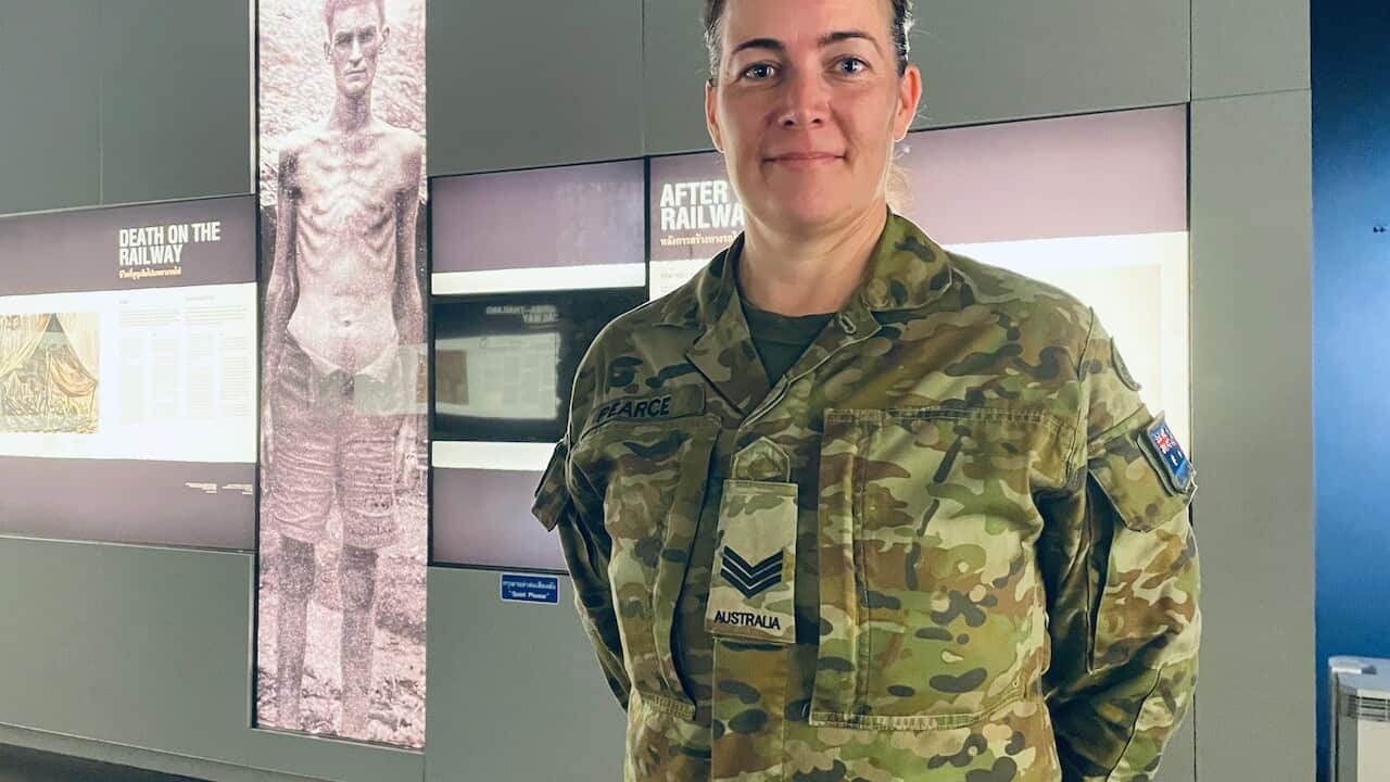 Sgt Pearce in front of a photo of her great uncle (SBS).jpeg
