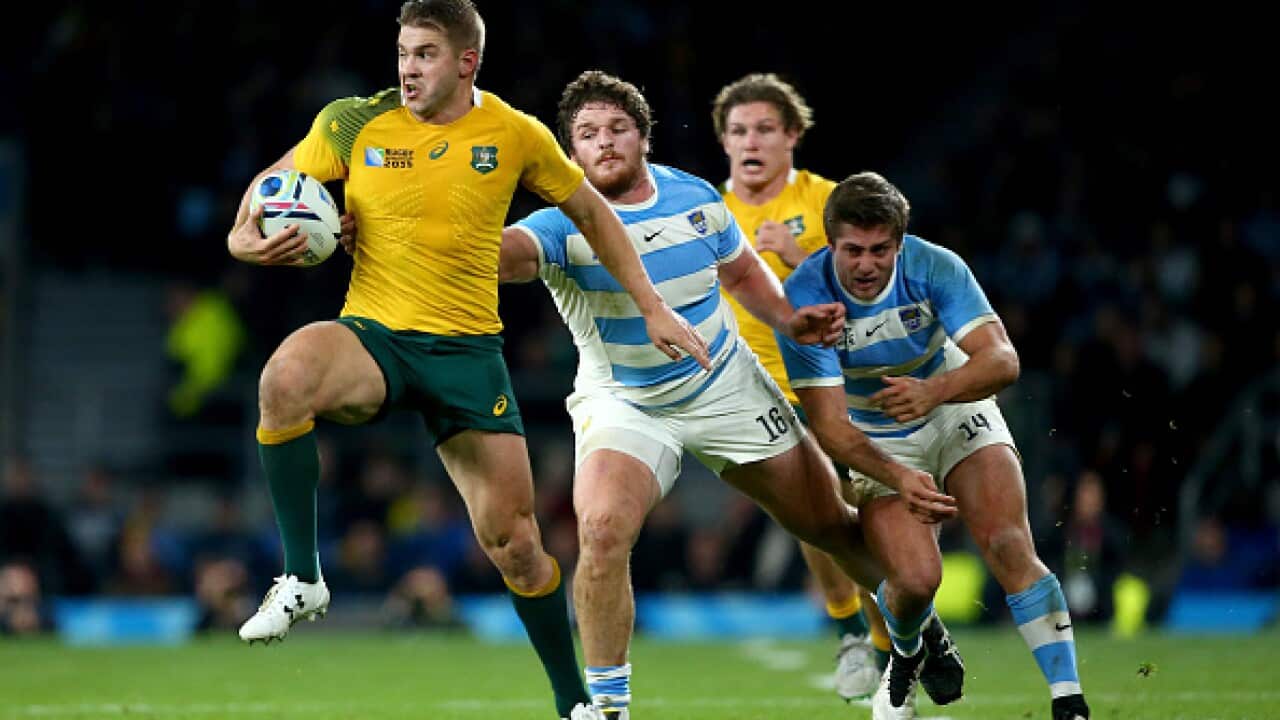 Drew Mitchell of Australia breaks the challenge of Julian Montoya of Argentina on the way to setting up Adam Ashley-Cooper (not pictured) to score Australia's 4th try of the game during the 2015 Rugby World Cup Semi Final match between Argentina and Austr