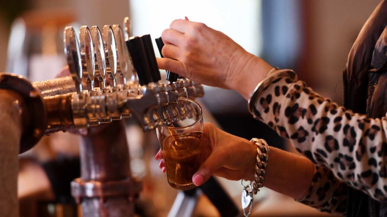 A barmaid pours a beer