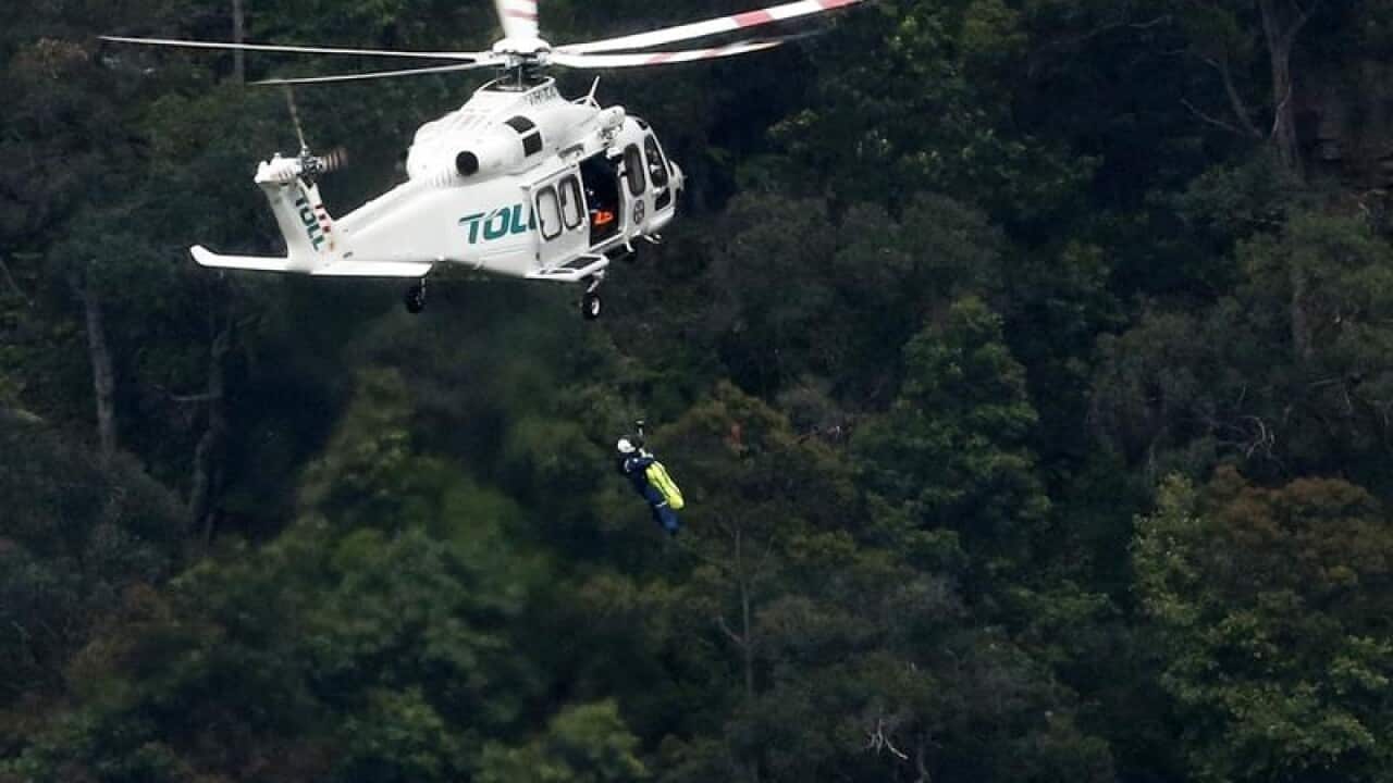 A man is winched into a rescue helicopter near Wentworth Falls