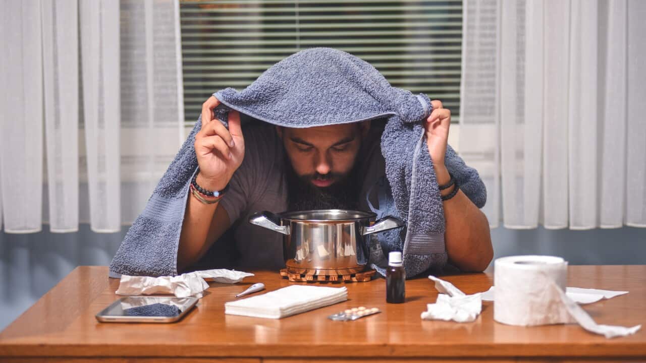 A person inhales with a herbs couple at home and measures the temperature