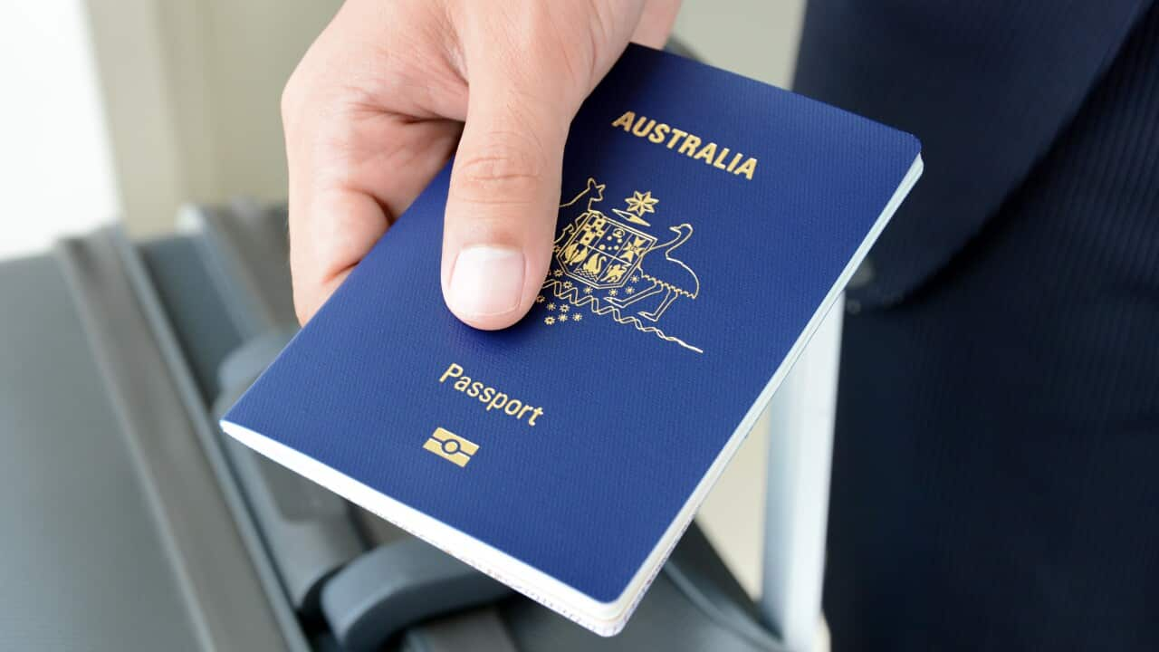 A hand holds an Australian passport