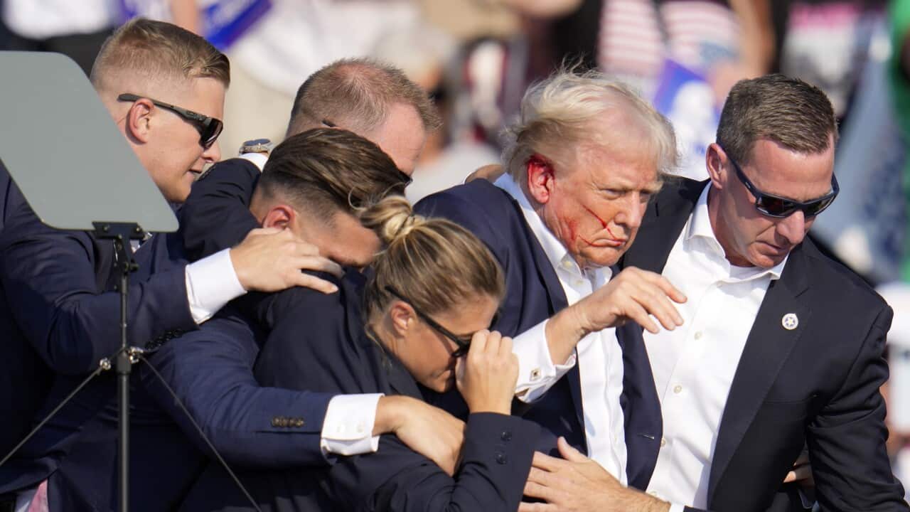 Republican presidential candidate former President Donald Trump is helped off the stage by U.S. Secret Service agents at a campaign event in Butler, Pa., on Saturday, July 13, 2024.