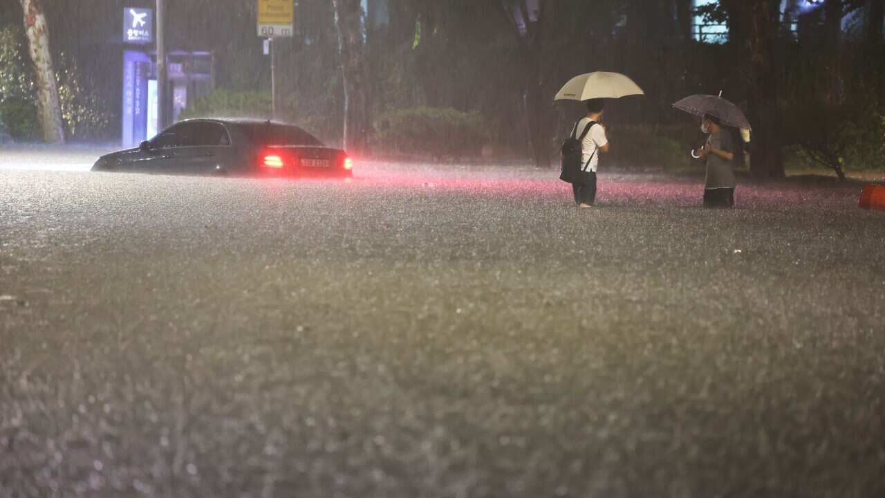 A vehicle is submerged in a flooded road in Seoul, Monday, Aug. 8, 2022.