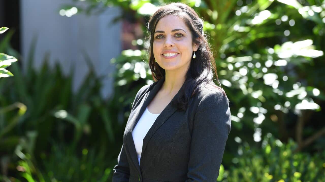 Liberal state MP Moira Deeming smiles outside by some trees.