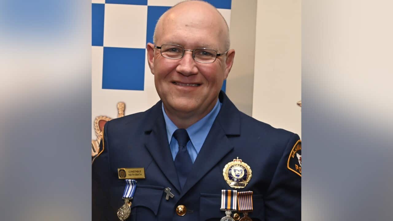 A police officer smiles at the camera