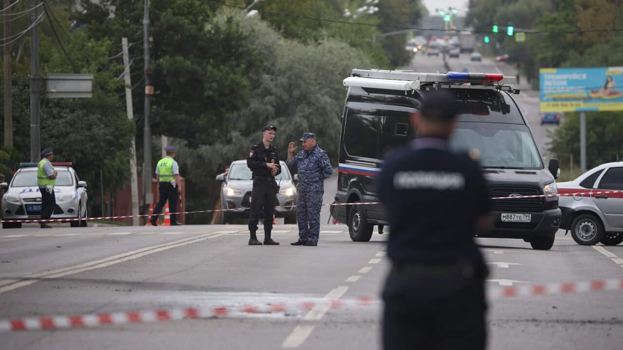 Russian police at the scene of a car bombing that is taped off.