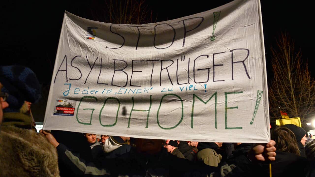 GERMANY, Dresden: PEGIDA protester carry banner that reads: Stop Asylum cheats in mass anti-Islam protest in Dresden, Germany on January 12, 2015. (AAP Image/NEWZULU/CHRISTOS STAMOS). NO ARCHIVING, CROWD SOURCED CONTENT, EDITORIAL USE ONLY