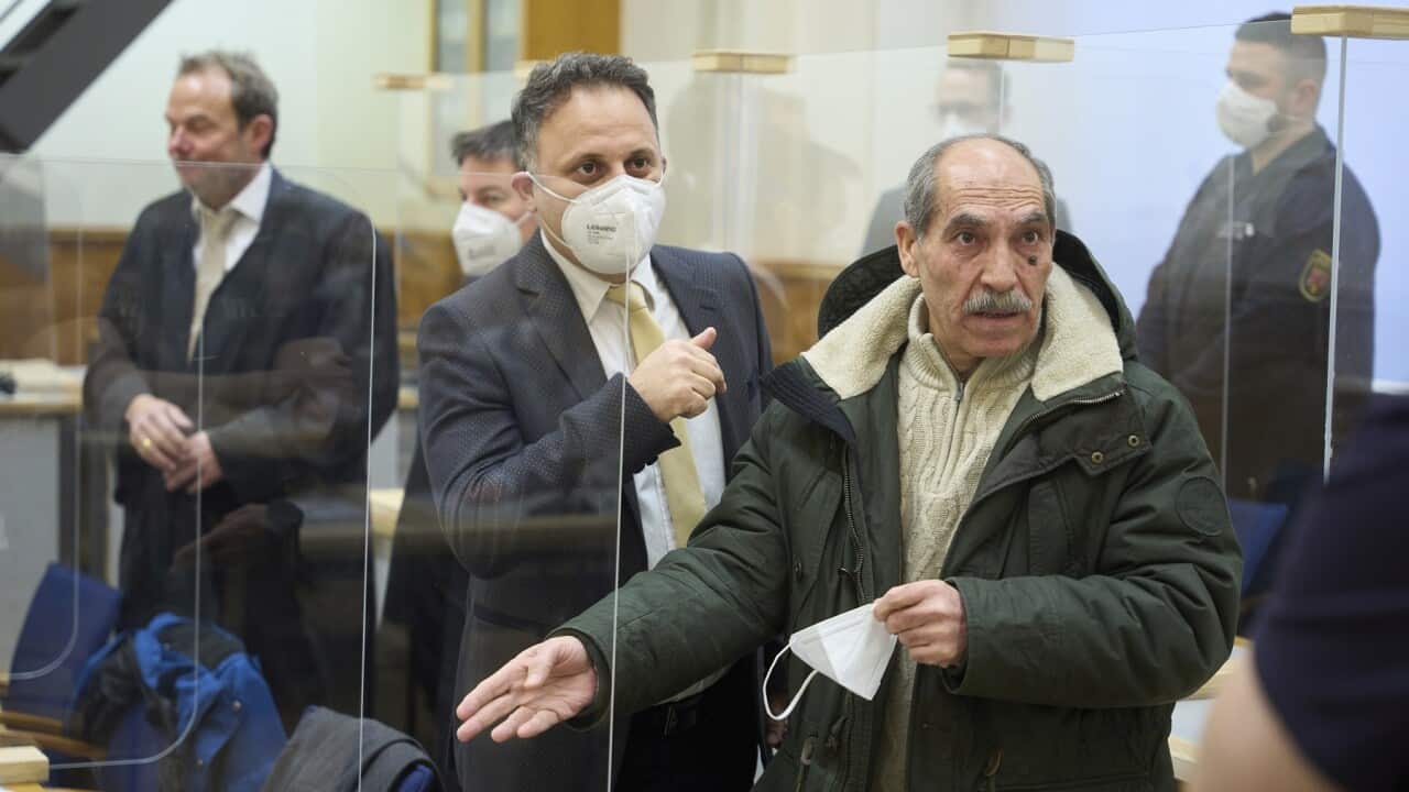 Anwar Raslan, right, stands in court before the pronouncement of the verdict