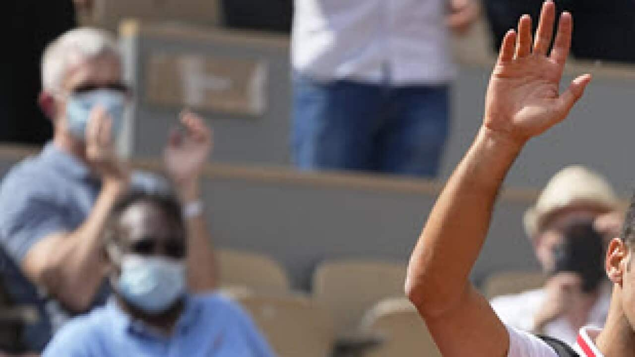 Serbia's Novak Djokovic waves to the crowd after Italy's Lorenzo Musetti retired from the match in their fourth round match on day 9, of the French Open tennis tournament at Roland Garros