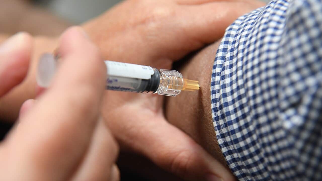 A man is seen receiving a flu immunisation shot as part of a work-provided Flu vaccination initiative in Rhodes, New South Wales, Australia.